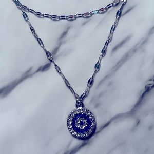 A double chain silver colour evil eye necklace.
